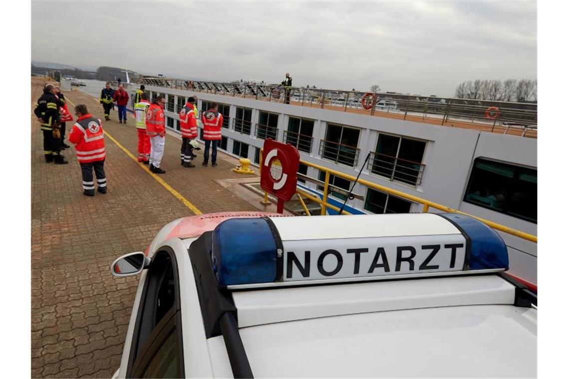 Rettungskräfte nehmen das Kabinenschiff in Empfang, das manövrierunfähig auf dem Rhein trieb. Foto: Thomas Frey