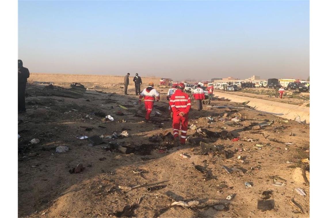 Über 170 Tote bei Flugzeugabsturz im Iran Rettungskräfte stehen am Ort eines Flugzeugabsturzes am Rande von Teheran. Bei dem Absturz der ukrainischen Passagiermaschine nahe Teheran sind nach Angaben der Hilfsorganisation iranischer Halbmond alle Insassen ums Leben gekommen. Foto: Mohammad Nasiri/AP/dpa