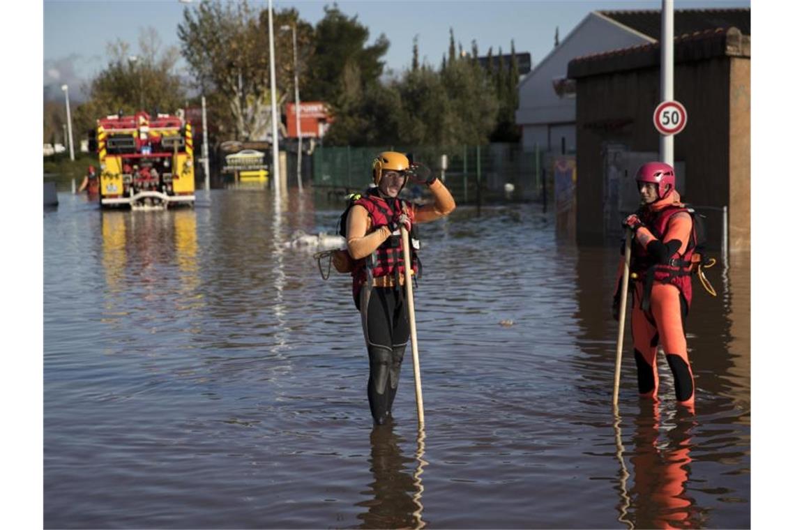 Rettungskräfte stehen auf dem Gelände eines Industrieparks. Foto: Daniel Cole/AP/dpa