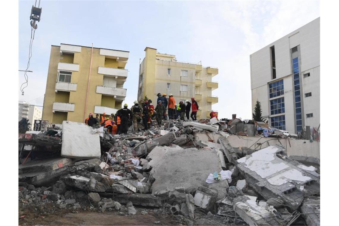 Rettungskräfte stehen auf den Trümmern eines eingestürzten Gebäudes. Bei dem schwersten Erdbeben seit Jahrzehnten kamen in Albanien mindestens 49 Menschen ums Leben. Foto: Zhang Liyun/XinHua/dpa