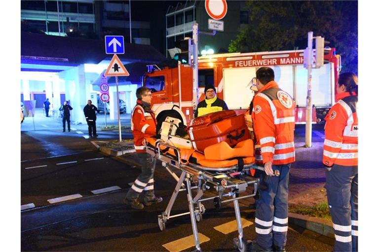 Rettungskräfte stehen vor einem Wagen der Feuerwehr in Mannheim. Foto: R.Priebe /Pr-Video/dpa