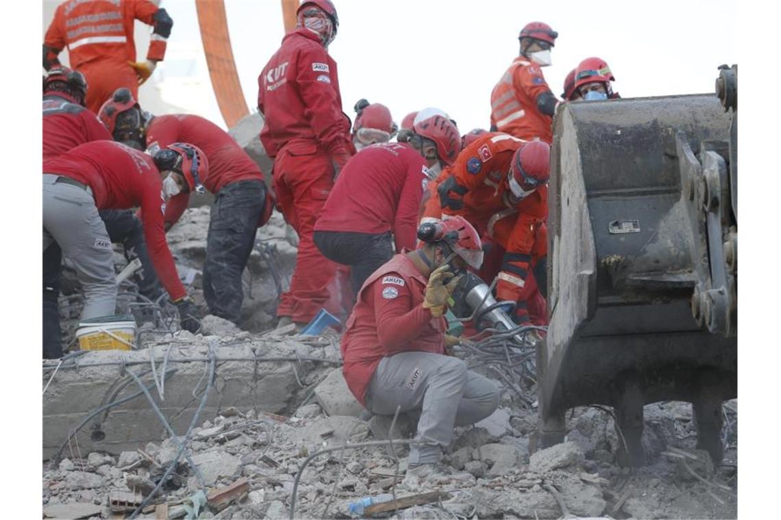 Rettungskräfte suchen in den Trümmern eines eingestürzten Gebäudes in Izmir nach Überlebenden. Foto: Darko Bandic/AP/dpa