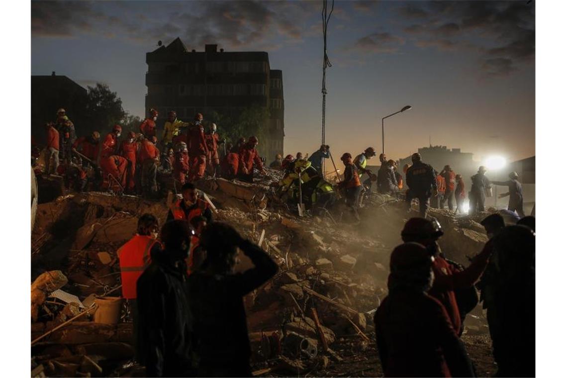 Rettungskräfte suchen in den Trümmern eines eingestürzten Gebäudes in Izmir nach Überlebenden. Foto: Darko Bandic/AP/dpa