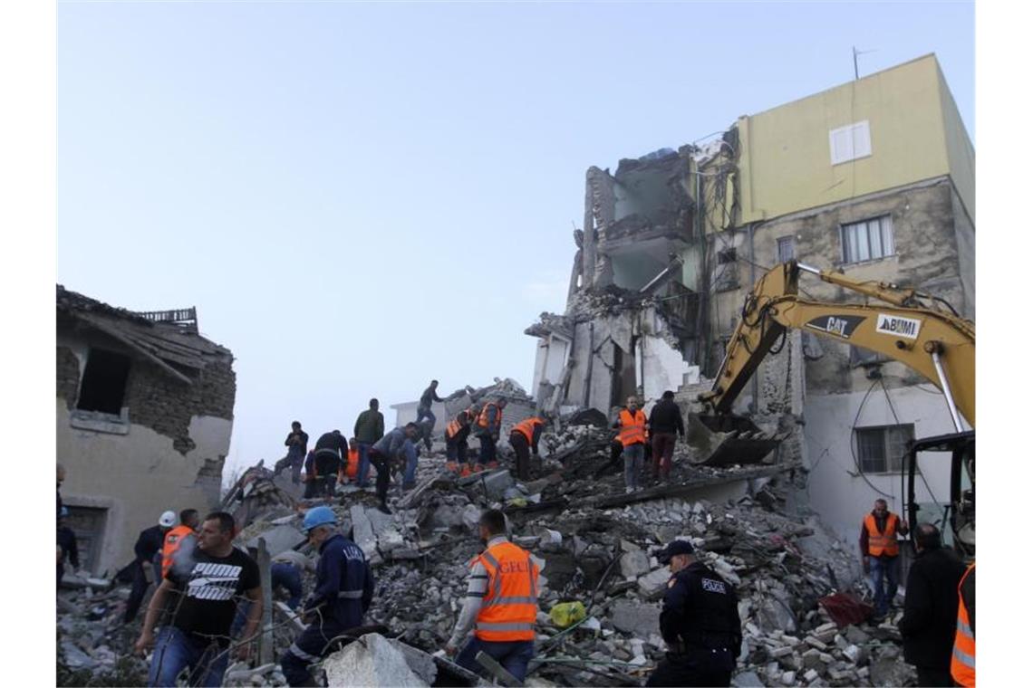 Rettungskräfte suchen in einem zerstörten Gebäude in Thumane nach Überlebenden. Foto: Hektor Pustina/AP/dpa