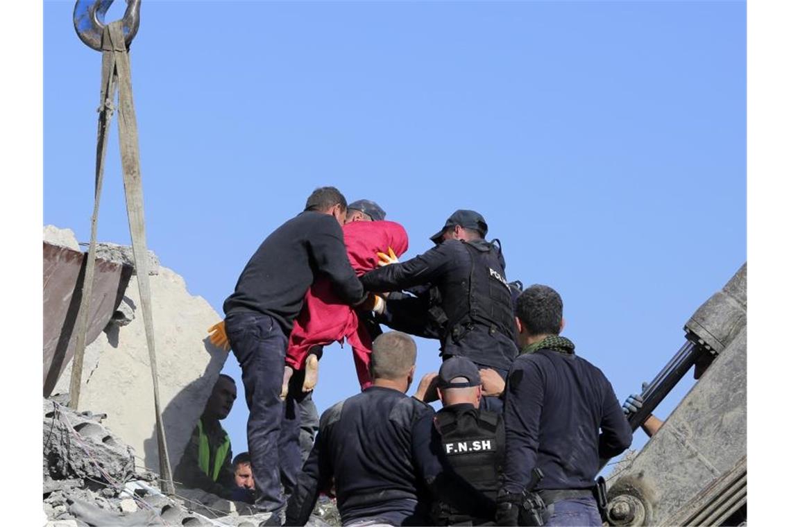 Rettungskräfte tragen die Leiche eines kleinen Mädchens in einer roten Decke aus einem zerstörten Gebäude. Foto: Visar Kryeziu/AP/dpa