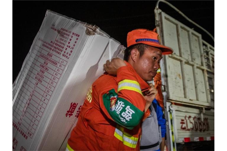 Rettungskräfte tragen Hilfsgüter in den Autonomen Kreis Yangbi Yi in der südwestchinesischen Provinz Yunnan. Ein Erdbeben der Stärke 7,4 hat den Nordwesten Chinas erschüttert. Das Zentrum lag nach Angaben des seismischen Netzwerks Geofon in Potsdam in der Provinz Qinghai und wurde in einer Tiefe von zehn Kilometern gemessen. Foto: XinHua/dpa