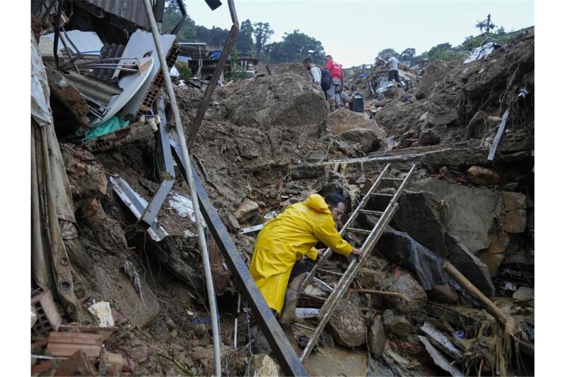 Mindestens 94 Tote nach Regen und Erdrutschen bei Rio Rettungskräfte und Anwohner suchen nach Opfern in einem von Erdrutschen betroffenen Gebiet in Petrópolis. Foto: Silvia Izquierdo/AP/dpa