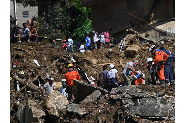 Rettungskräfte und Anwohner suchen nach Opfern in einem von Erdrutschen betroffenen Gebiet in Petropolis. Foto: Andre Borges/dpa