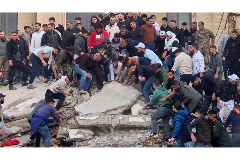 Rettungskräfte und Anwohner suchen nach Überlebenden in den Trümmern eines eingestürzten Gebäudes.