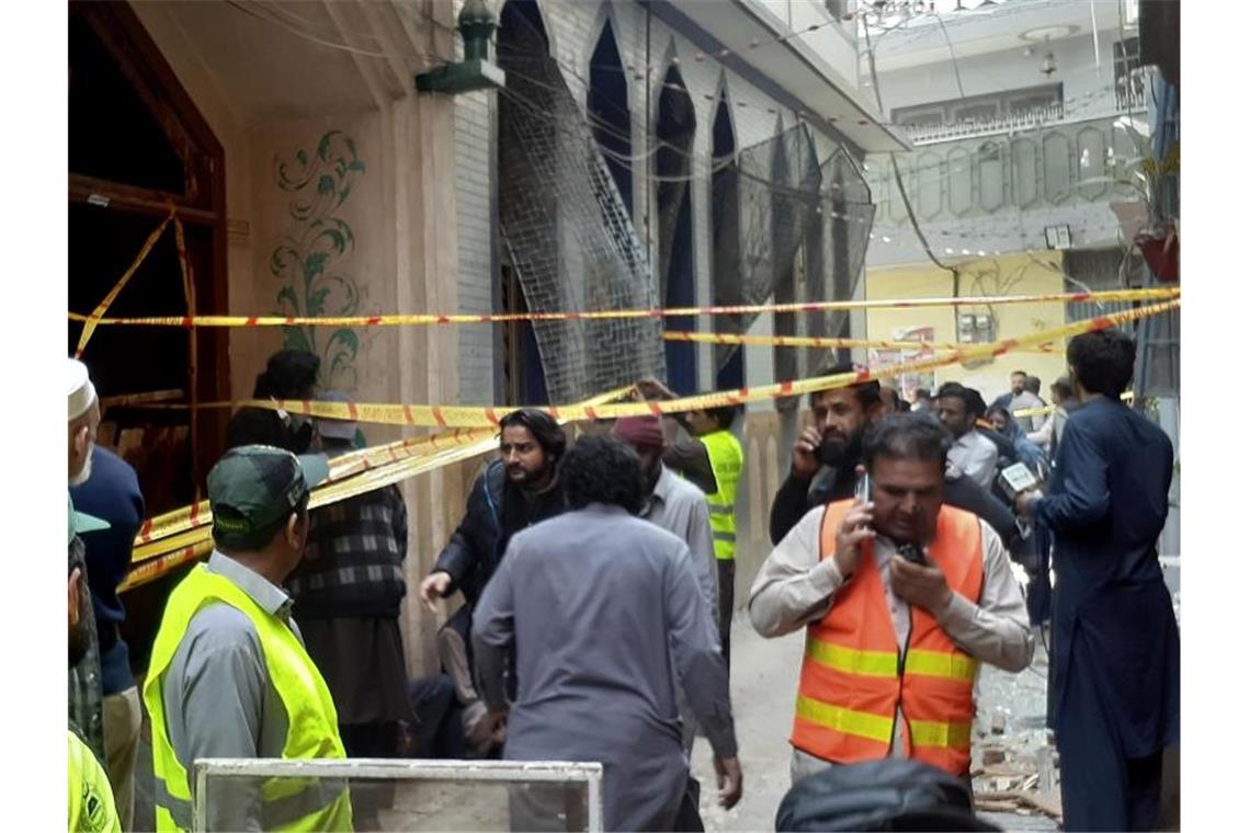 60 Tote bei IS-Selbstmordanschlag auf Moschee in Pakistan Rettungskräfte und Freiwillige versammeln sich am Ort der Bombenexplosion. Foto: Muhammad Sajjad/AP/dpa