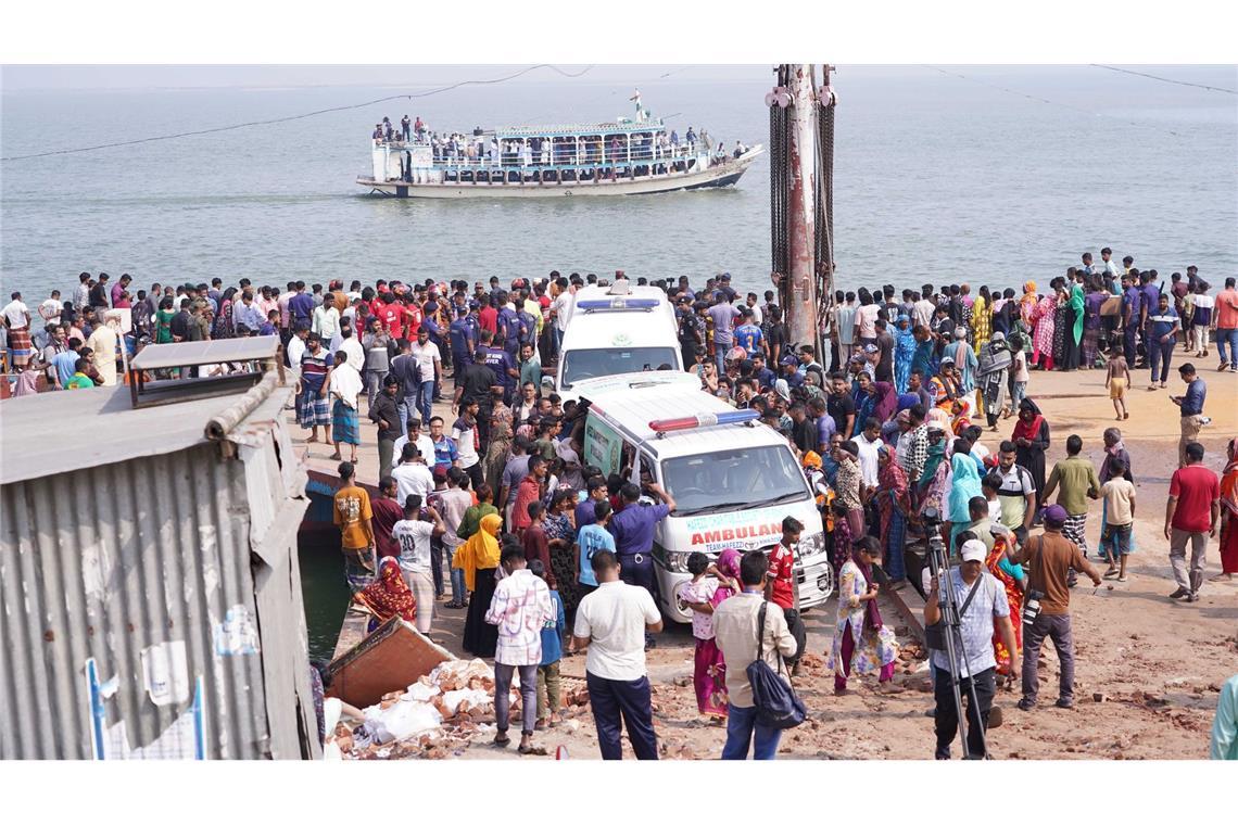 Rettungskräfte und zahlreiche Menschen versammeln sich an einer Unfallstelle, nachdem ein Bus in den Fluss Padma stürzte.