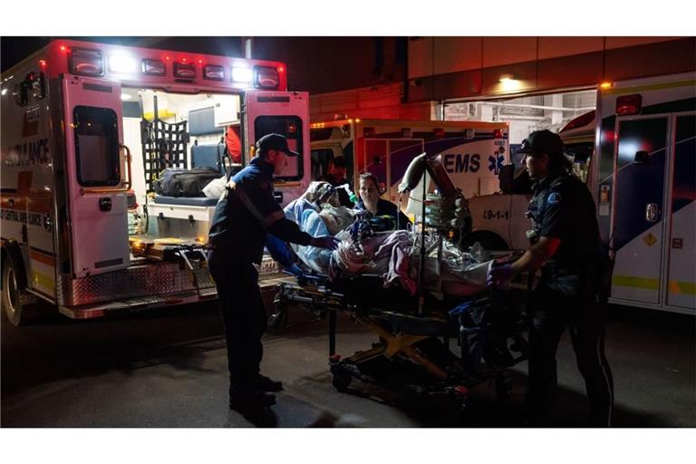 Rettungssanitäter laden nach einem Brand auf dem Stützpunkt der kanadischen Streitkräfte bei Wainwright, Alberta, eine verletzte Person im Wainwright Health Center in einen Krankenwagen.