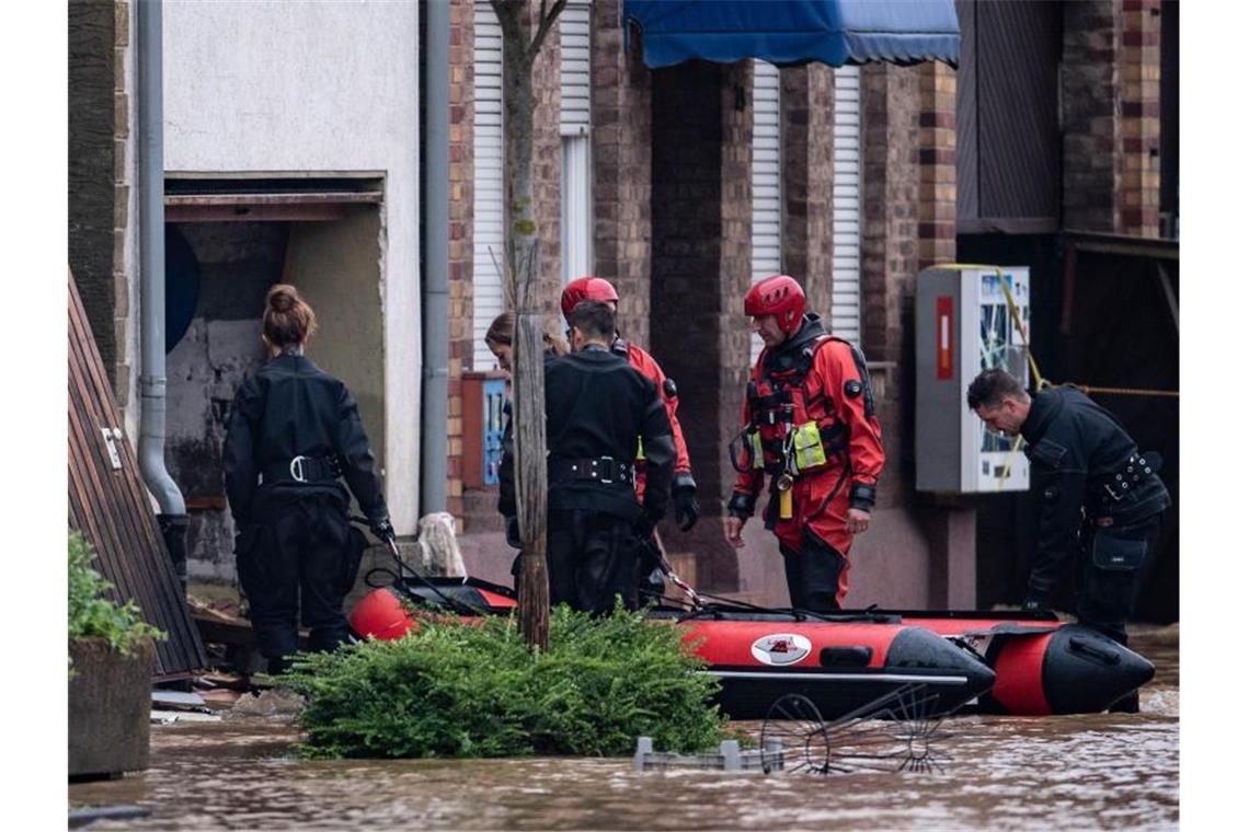 Menschen bei Hauseinstürzen in Erftstadt gestorben Rettungsschwimmer und Polizeitaucher bergen Menschen mit einem Schlauchboot in Erftstadt. Foto: Marius Becker/dpa