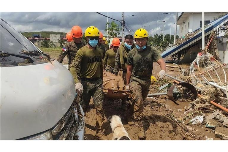 Rettungsteams kämpfen sich durch Schlamm und Trümmer.