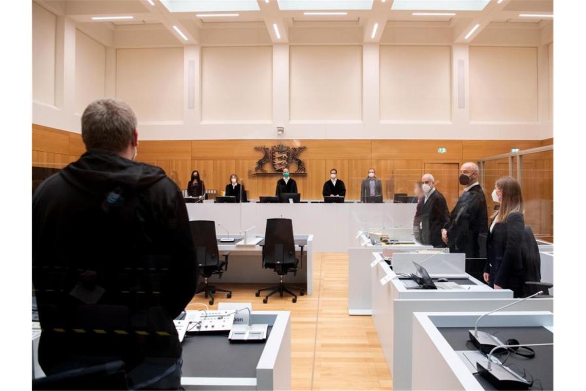 Angriff vor „Querdenker“-Demonstration: Mehrere Jahre Haft Richter, ein Angeklagter (4.v.r) und Rechtsanwälte stehen im Gerichtssaal. Foto: Bernd Weißbrod/dpa/Archiv