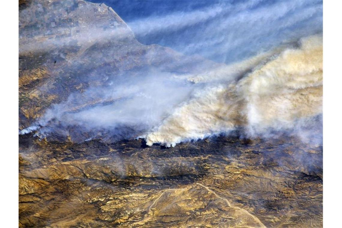 Riesige Rauchwolken sind von der Internationalen Raumstation (ISS) aus über Südkalifornien (USA) zu sehen. Die Waldbrände im Westen der USA sind aus Expertensicht auch eine Folge des Klimawandels. Foto: Randy Bresnik/Nasa/dpa