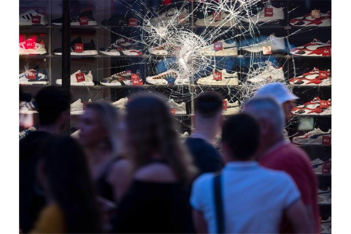 Nach Chaos-Nacht: Politik und Polizei beraten über Folgen Risse sind in einer beschädigten Scheibe eines Einzelhandelsgeschäfts zu sehen. Foto: Marijan Murat/dpa