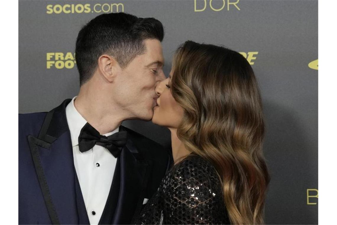 Robert Lewandowski bekommt von Ehefrau Anna ein Küsschen in Paris. Foto: Christophe Ena/AP/dpa