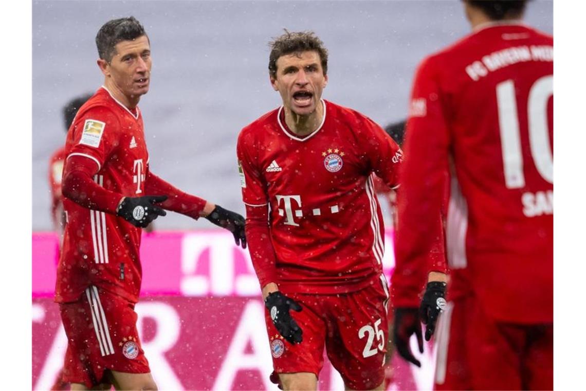 Robert Lewandowski, Thomas Müller und Leroy Sané (l-r) jubeln über das Bayern-Tor zur 2:1-Führung gegen den SC Freiburg. Foto: Sven Hoppe/dpa