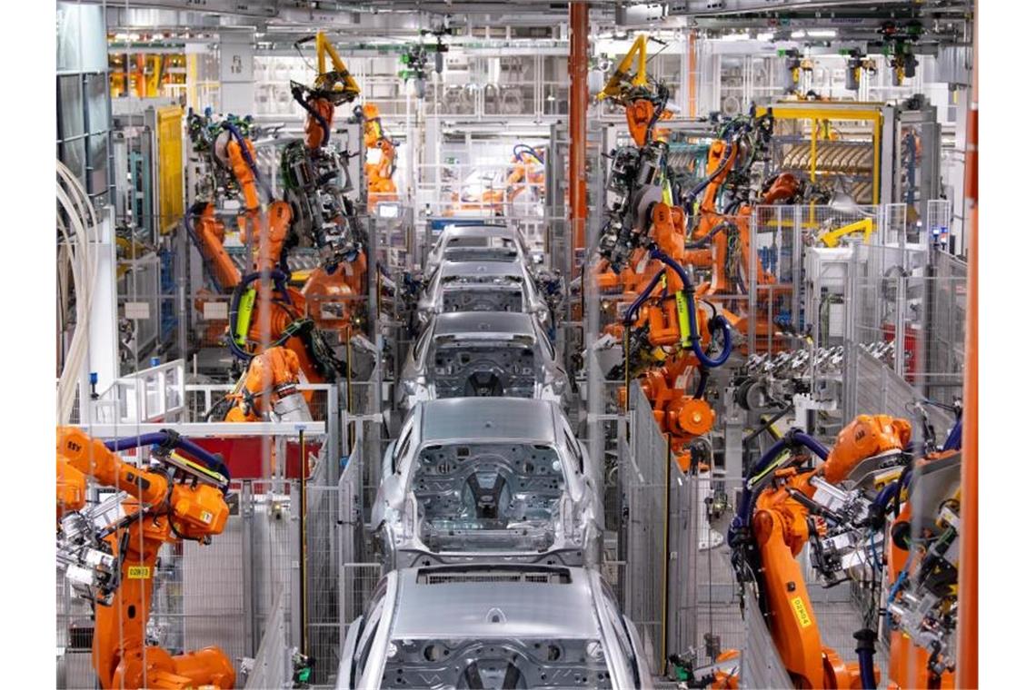 Industrie wetzt Corona-Scharte 2021 nur zum Teil aus Roboter von ABB arbeiten an der Karosserie von verschiedenen BMW-Modellen im BMW-Stammwerk. Die Produktion der Industrie in Deutschland hat trotz eines Dämpfers zum Jahresende im Gesamtjahr 2021 zugelegt. Foto: Sven Hoppe/dpa