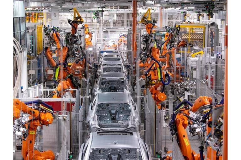 Roboter von ABB arbeiten an der Karosserie von verschiedenen BMW-Modellen im BMW-Stammwerk. Die Produktion der Industrie in Deutschland hat trotz eines Dämpfers zum Jahresende im Gesamtjahr 2021 zugelegt. Foto: Sven Hoppe/dpa