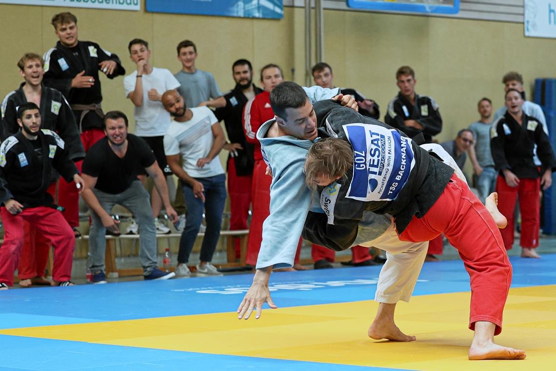 Roland Gőz (rote Hose) siegt angefeuert von seinen Teamkameraden und den beiden Co-Trainern. Foto: Alexander Becher