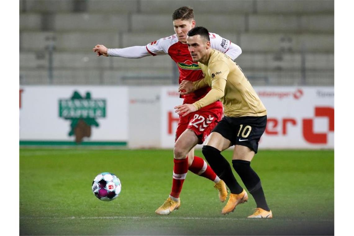 Roland Sallai (l) vom SC Freiburg und Filip Kostic von Eintracht Frankfurt in Aktion. Foto: Philipp von Ditfurth/dpa