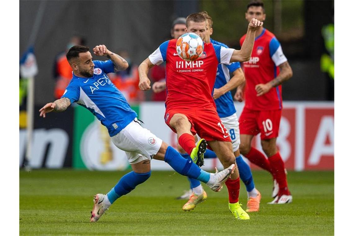 Rostocks Calogero Rizzuto (l) und Robert Leipertz vom FC Heidenheim im Zweikampf. Foto: Jens Büttner/dpa-Zentralbild/dpa