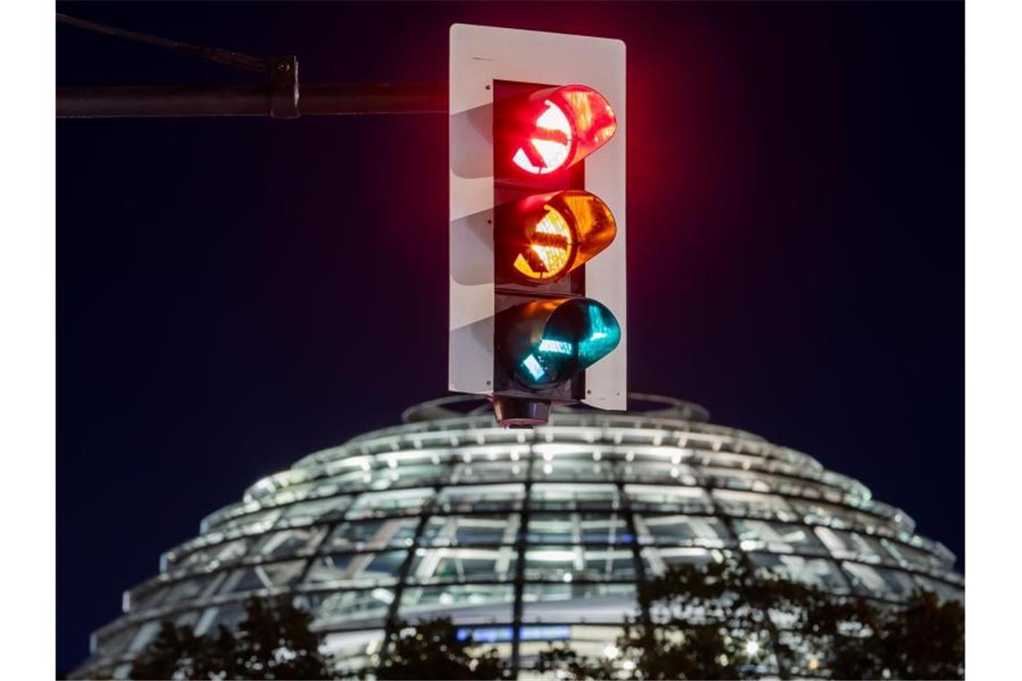 Ampel: SPD und FDP weisen Warnung vor Scheitern zurück Rot-gelb-grün - eine Ampel leuchtet vor der Kuppel des Reichstagsgebäudes (in einer Langzeitbelichtung) in allen drei Phasen. Foto: Christoph Soeder/dpa
