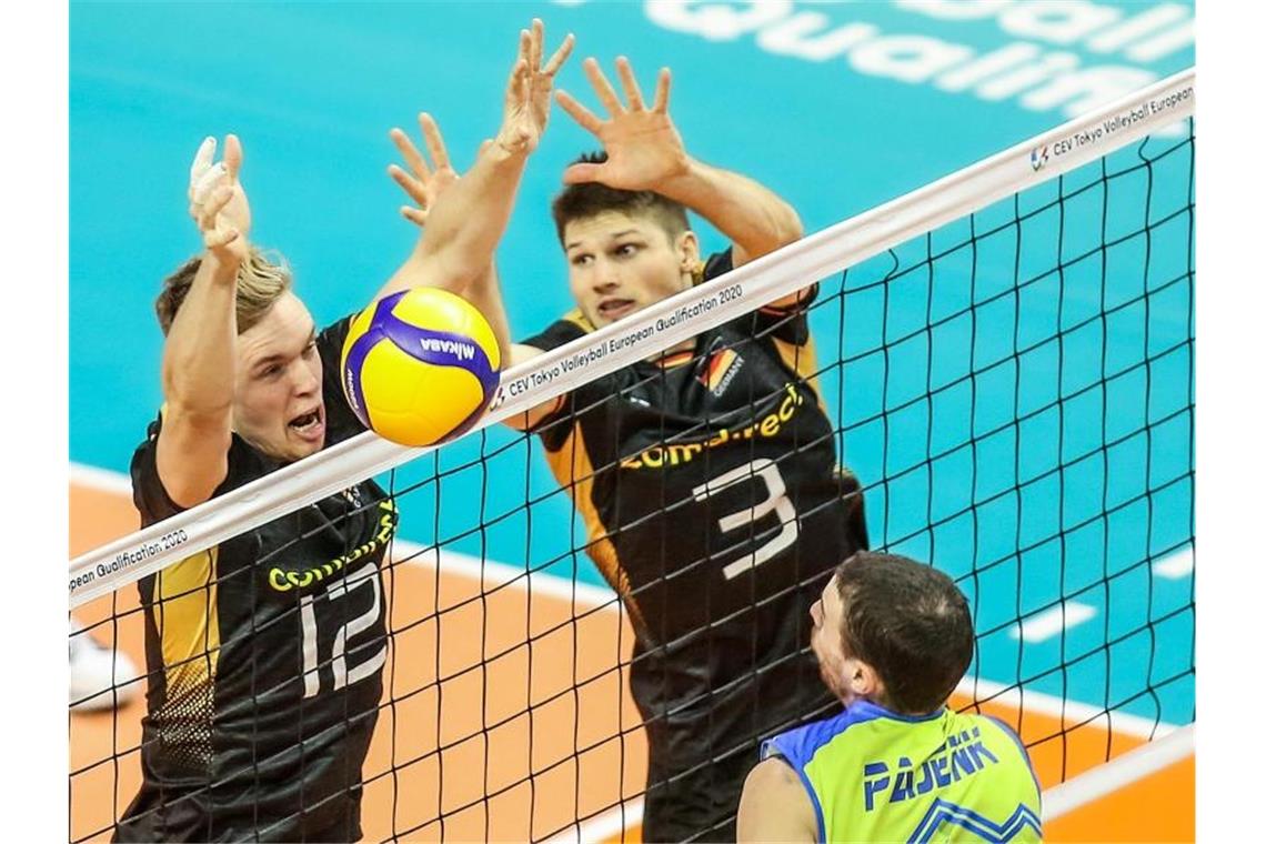 Sehnsuchtsziel Tokio rückt für Volleyballer näher Ruben Schott (M) und Anton Brehme (r) blocken einen Ball des Slowenen Alen Pajenk. Foto: Andreas Gora/dpa