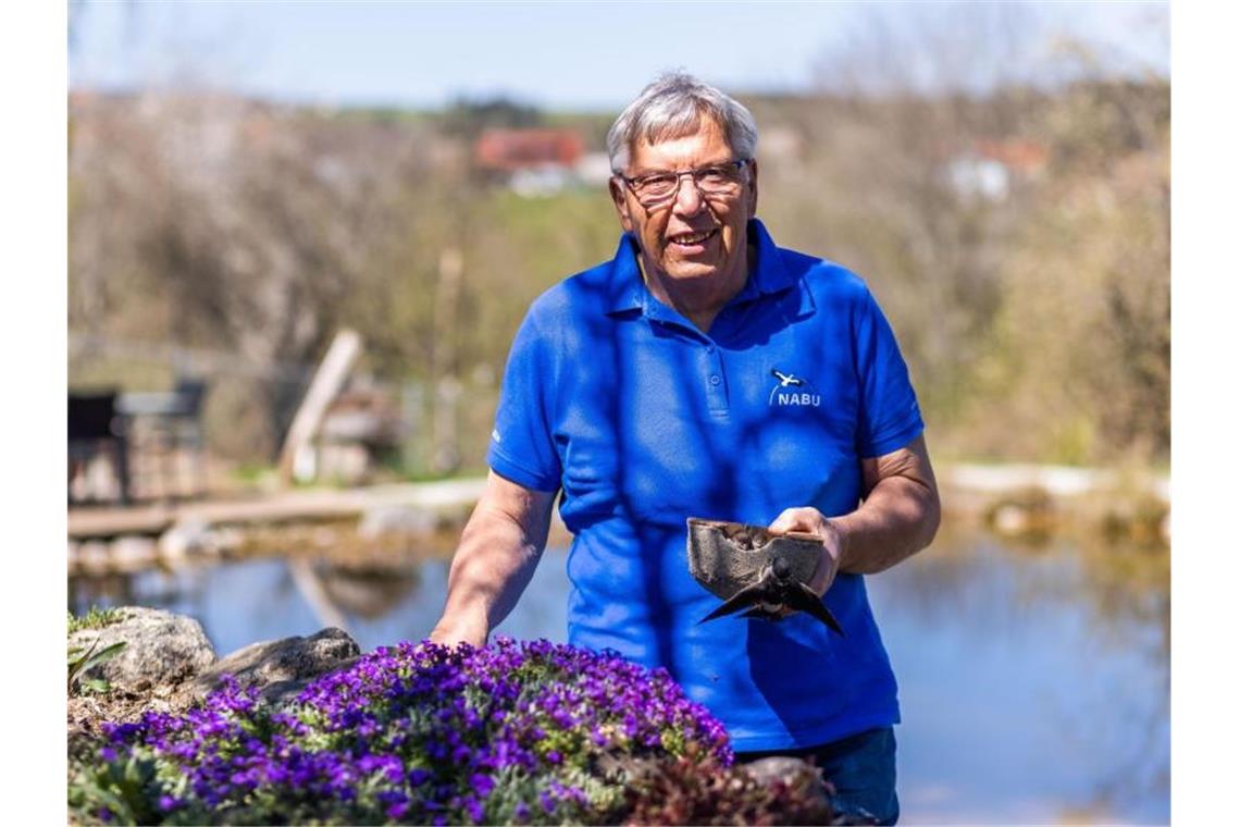 Rudi Apel steht mit einem künstlichen Schwalbennest in der Hand in seinem Garten. Foto: Philipp von Ditfurth/dpa/Aktuell