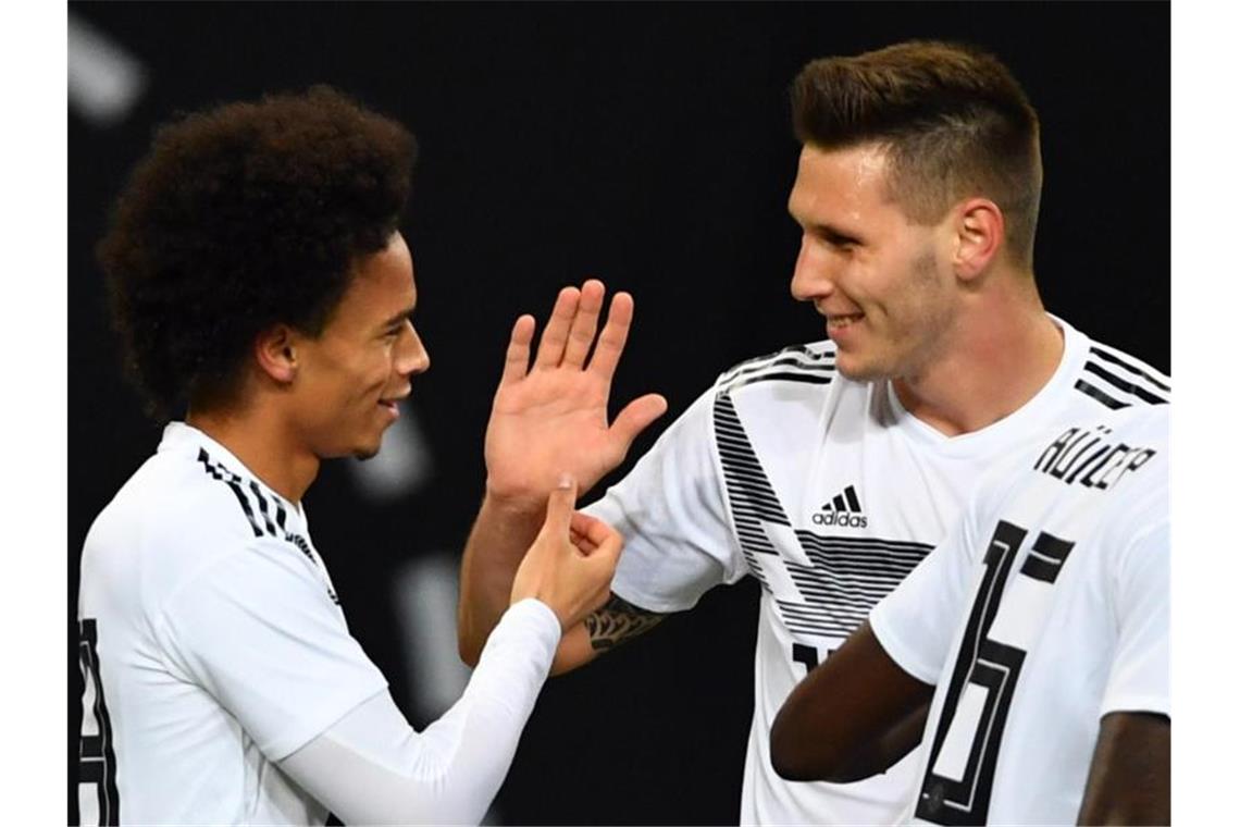 Rückkehrer: Leroy Sané (l) und Niklas Süle klatschen ab. Foto: Soeren Stache/dpa