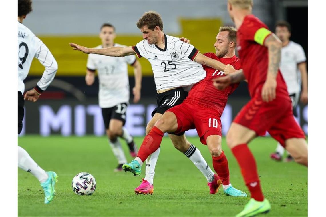 Rückkehrer Thomas Müller (2.v.l.) kämpft mit dem Dänen Christian Eriksen (2.v.r.) um den Ball. Foto: Christian Charisius/dpa