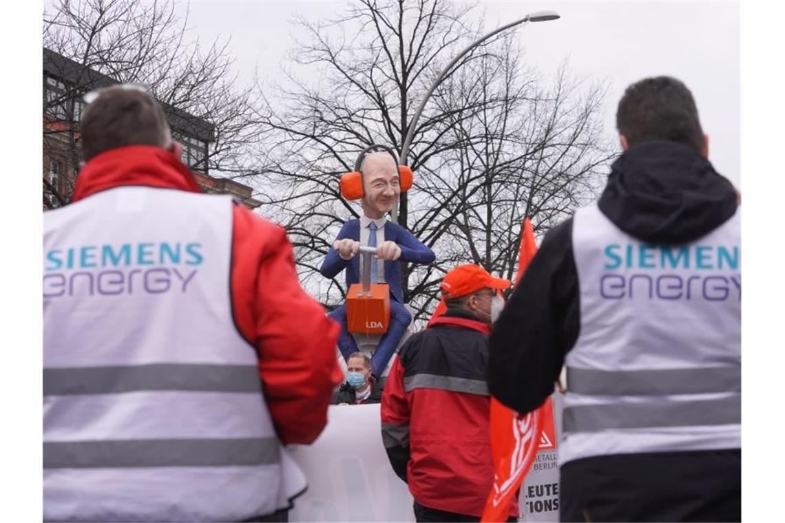 Lob und Protest bei Siemens Hauptversammlung Rund 150 Siemens-Beschäftigte protestieren vor einer lebensgroßen Plastik des Vorstandsvorsitzenden Roland Busch gegen die Abspaltung des Bereichs "Elektrische Großantriebe". Foto: Joerg Carstensen/dpa