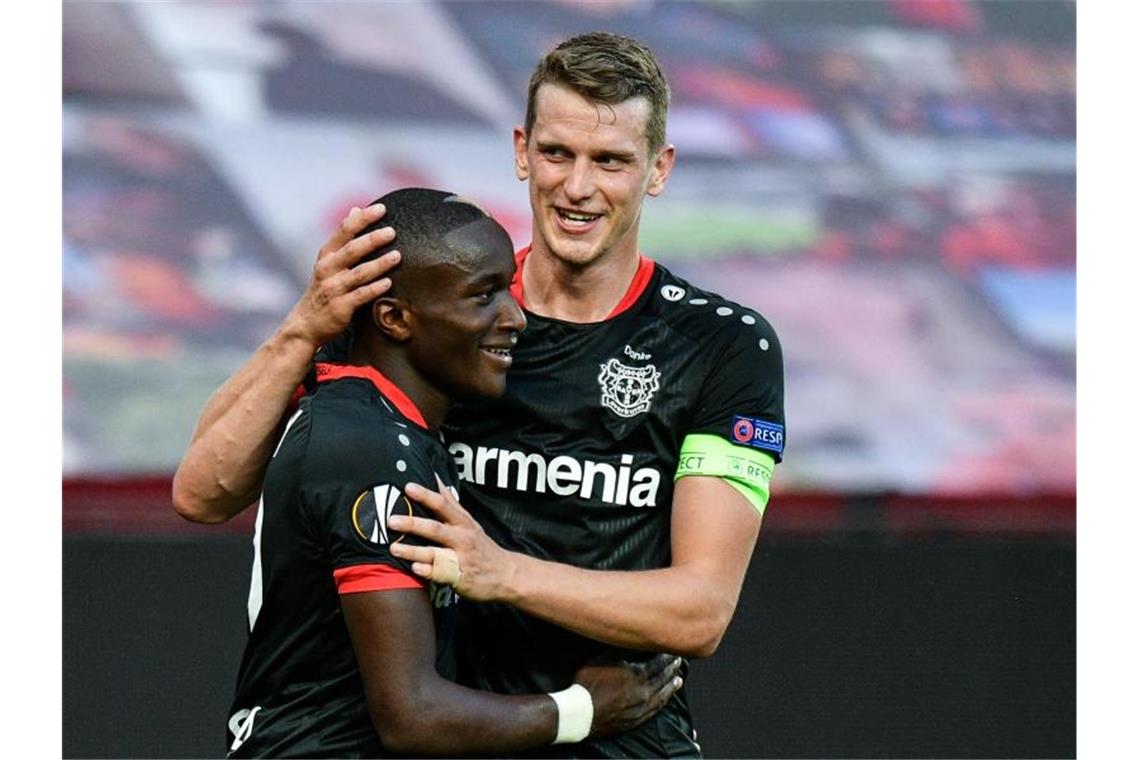 Runde weiter: Bayer-Kapitän Lars Bender (r) gratuliert dem Torschützen Moussa Diaby. Foto: Sascha Schuermann/AFP-Pool/dpa