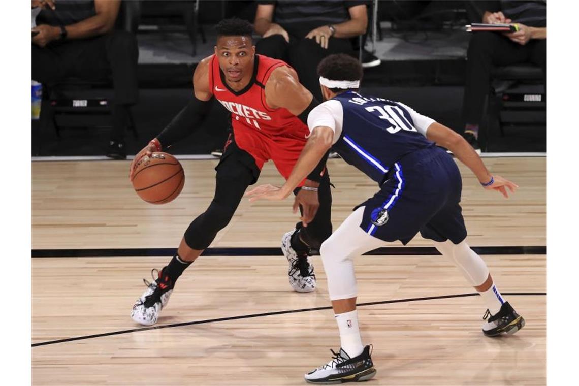 Russell Westbrook (l) von den Houston Rockets dribbelt gegen Seth Curry (r) von den Dallas Mavericks. Foto: Mike Ehrmann/POOL Getty Images/AP/dpa