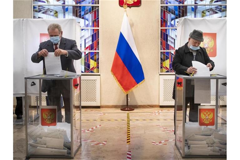 Russische Bürger geben ihre Stimmzettel ab. Foto: Mindaugas Kulbis/AP/dpa
