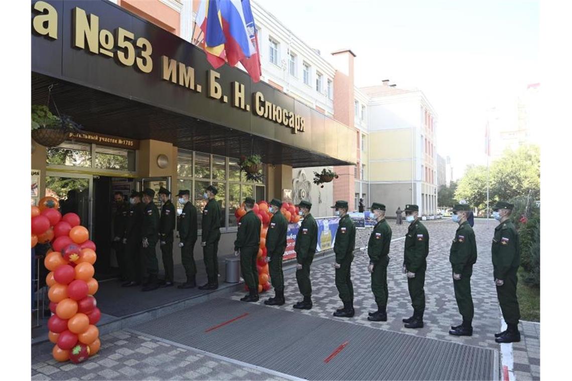 Wahl in Russland gestartet - Beobachter kritisieren Betrug Russische Soldaten stehen vor einem Wahllokal in Rostow am Don an. Foto: Uncredited/AP/dpa