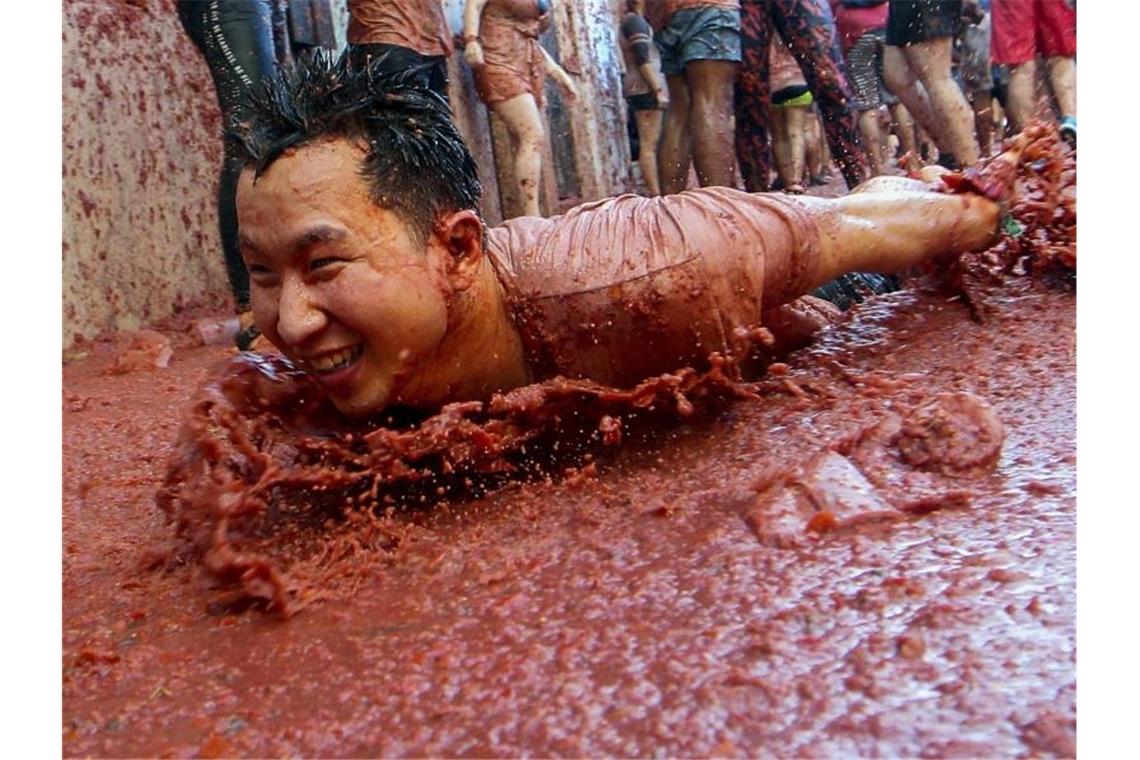 Tomatenkrieg in Spanien: 22.000 Menschen bei „La Tomatina“ Rutschpartie: 150 Tonnen Tomaten verwandeln die kleine Stadt Buñol bei Valencia in glitschiges Terrain. Foto: Alberto Saiz/AP