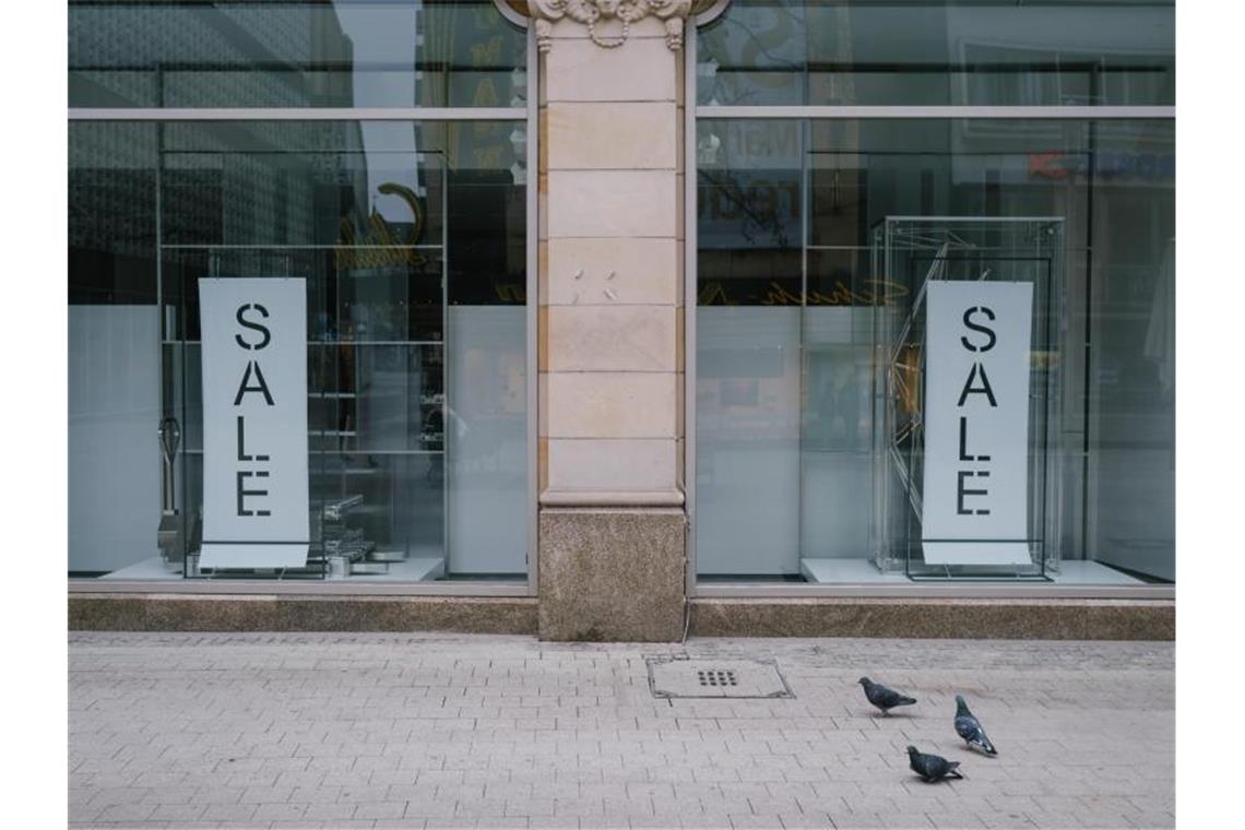 „Sale“ steht im leeren Schaufenster einer Modekette in der Innenstadt von Hannover. Foto: Ole Spata/dpa