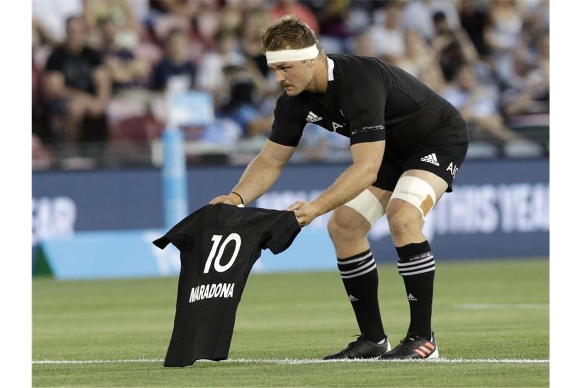 Sam Cane, Kapitän der „All Blacks“, legt vor dem Spiel der neuseeländischen Rugby-Nationalmannschaft gegen Argentinien das All-Black-Trikot mit Maradonas Nummer 10 auf das Spielfeld. Foto: Rick Rycroft/AP/dpa