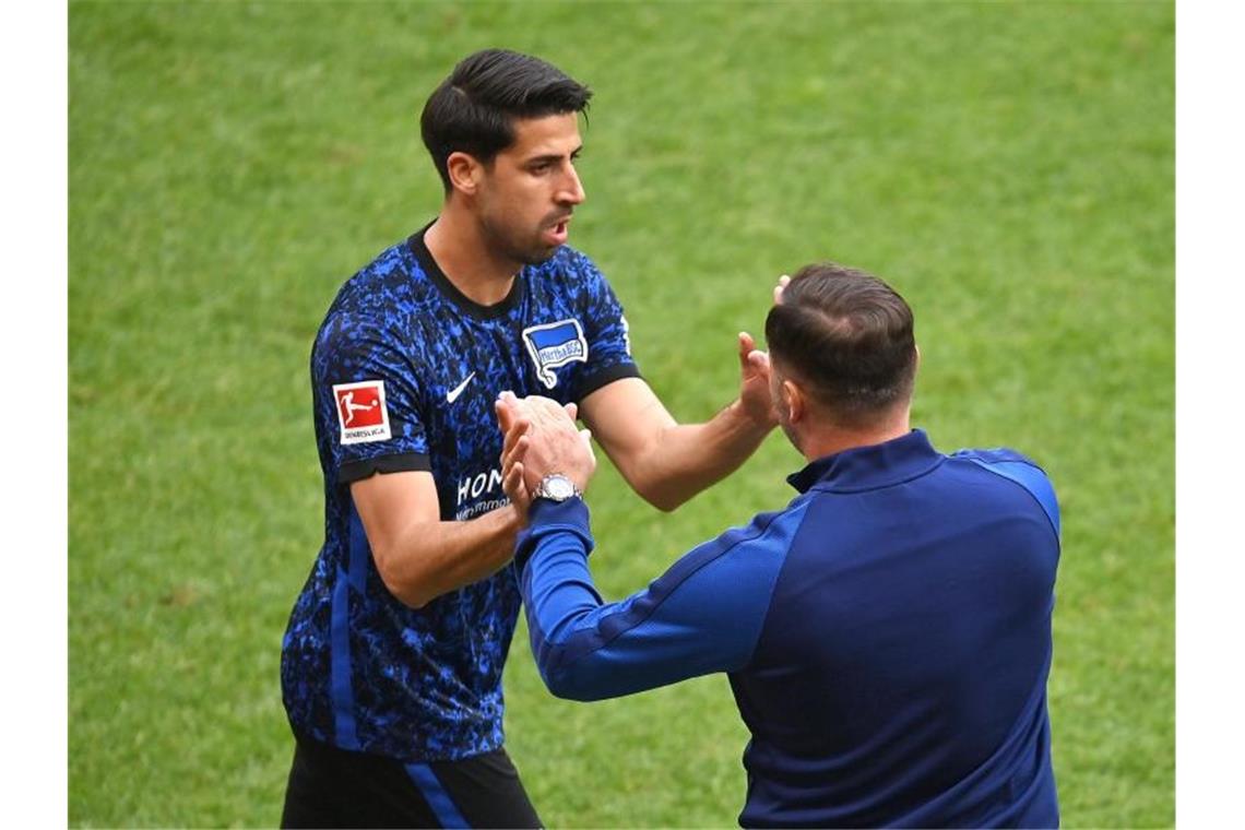 Sami Khedira (l) und Hertha-Trainer Pal Dardai freuen sich über den verdienten Punktgewinn. Foto: Torsten Silz/dpa