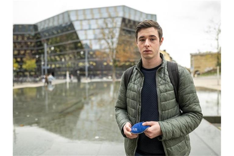 Samuel K. steht auf dem Platz der Alten Synagoge und hält eine Kippa in der Hand. Foto: Patrick Seeger/dpa