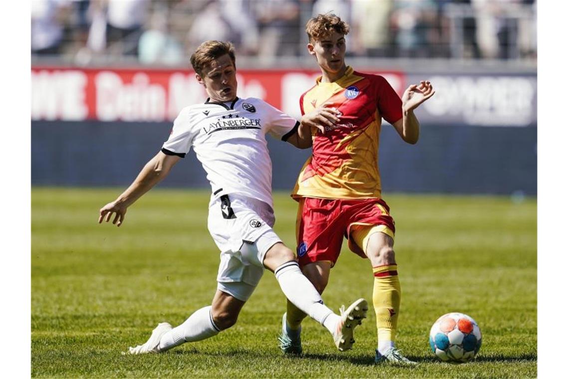 Sandhausens Carlo Sickinger (l) und Karlsruhes Dominik Kother kämpfen um den Ball. Foto: Uwe Anspach/dpa/Archivbild