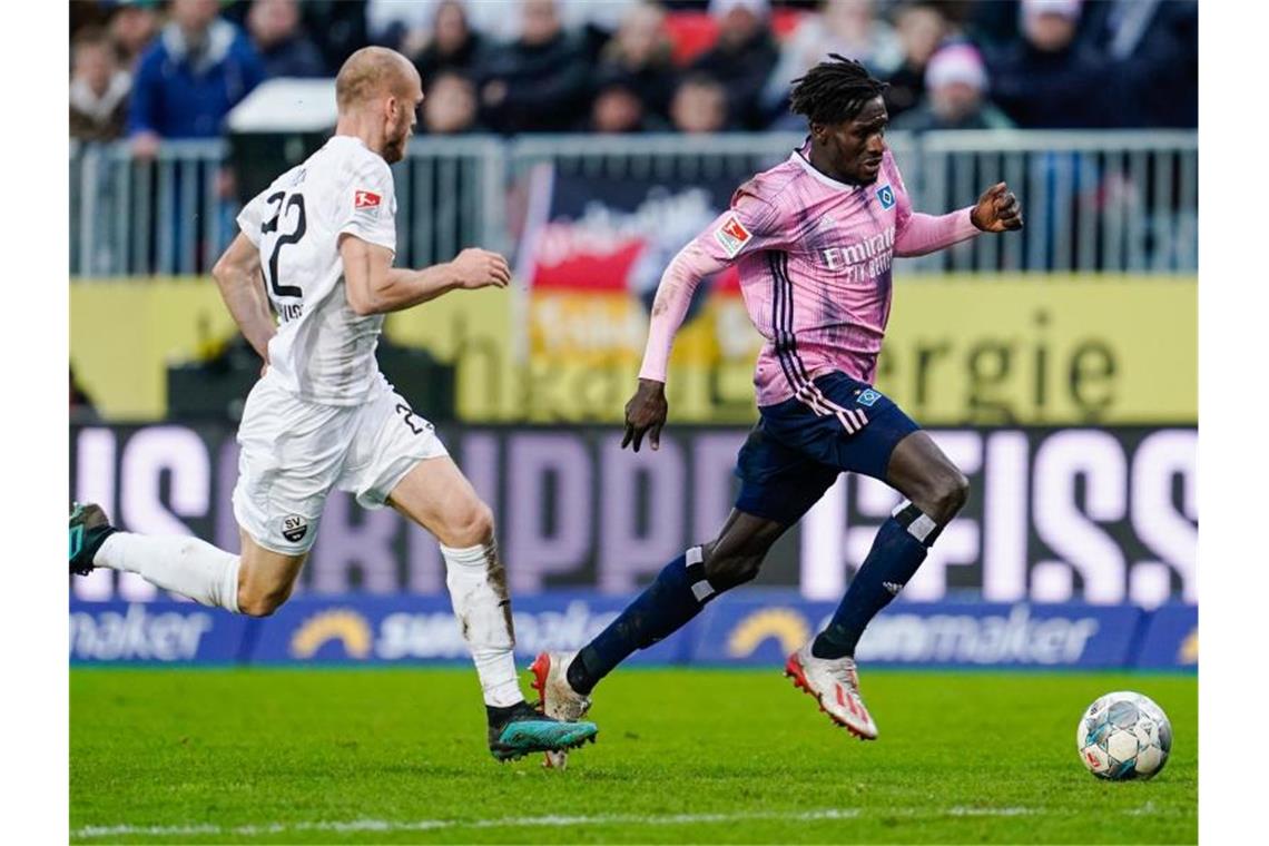 Sandhausens Gerrit Nauber (l.) und Hamburgs Bakery Jatta kämpfen um den Ball. Foto: Uwe Anspach/dpa