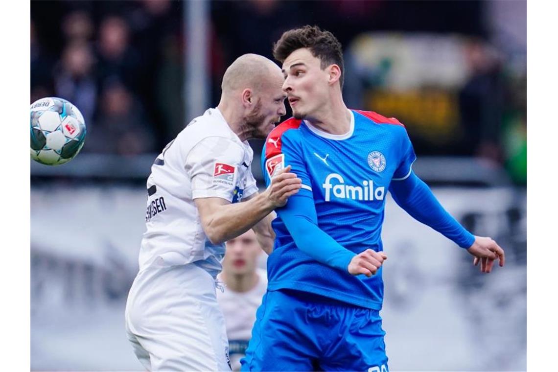 Führungstrio schwächelt - Trainerdiskussion beim VfB Sandhausens Gerrit Nauber (l) und Kiels Janni Luca Serra kämpfen um den Ball. Foto: Uwe Anspach/dpa