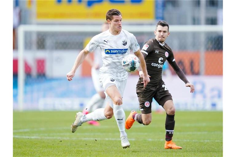 Sandhausens Kevin Behrens (l) kämpft um den Ball. Foto: Uwe Anspach/dpa/Archivbild