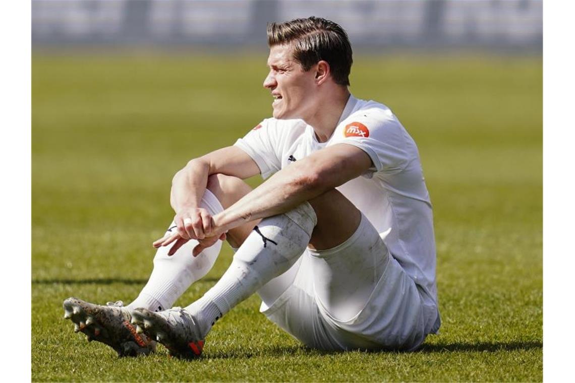 Sandhausens Kevin Behrens sitzt auf dem Spielfeld. Foto: Uwe Anspach/dpa/Archivbild