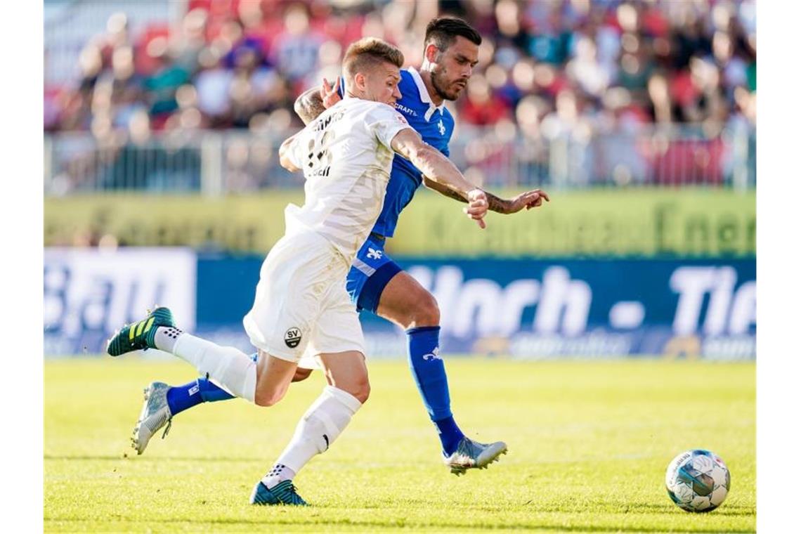 Sandhausens Kevin Behrens (vorne) und Darmstadts Dario Dumic kämpfen um den Ball. Foto: Uwe Anspach