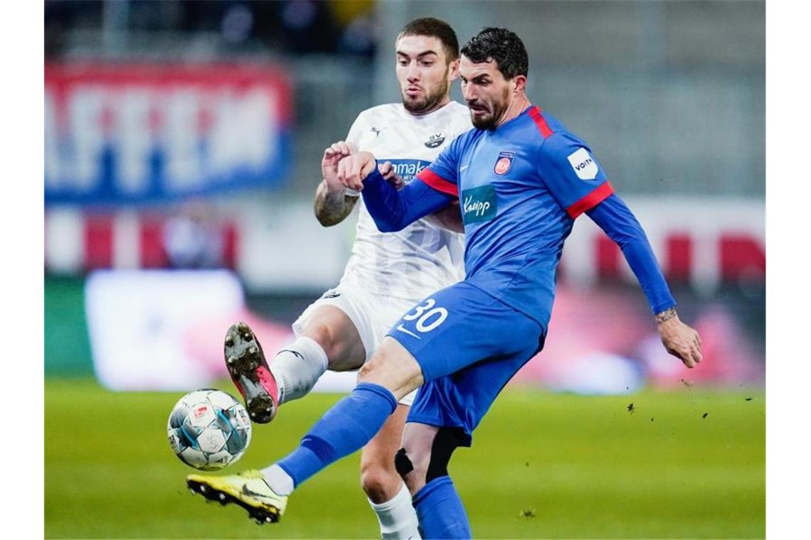 Zweitligist Heidenheim bleibt oben dran: Sieg in Sandhausen Sandhausens Marlon Frey (l.) und Heidenheims Norman Theuerkauf kämpfen um den Ball. Foto: Uwe Anspach/dpa